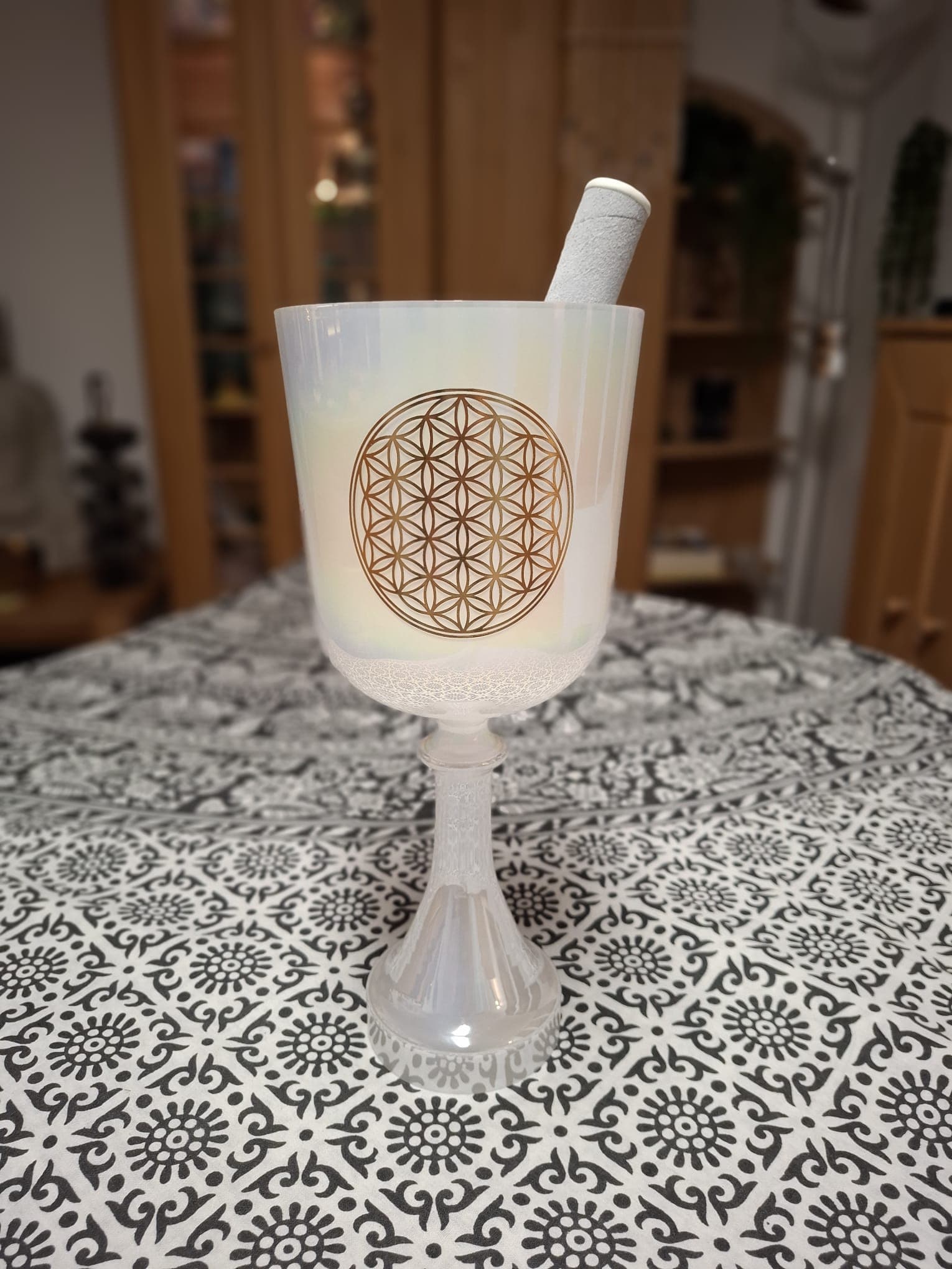 Kristallklangschale mit Blume-des-Lebens-Symbol auf einem Meditationstuch